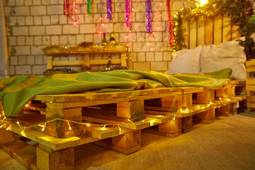A loft style and rustic bedroom with Christmas or New Year decorations. Poor room in the attic. A...