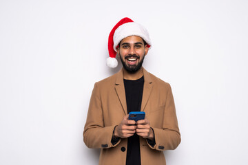 Businessman dressed in Christmas hat of Santa Claus, looking at mobile phone, on white background. Christmas celebration concept.