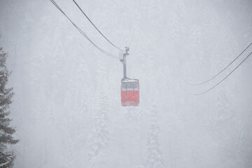 red skilift cabine in the strong snowfall in the mountains of the Caucasus