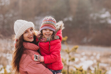 Fototapeta premium Mother with little daughter in a winter forest