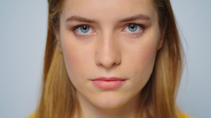 Obraz premium Closeup beautiful woman raising head at camera on grey background.