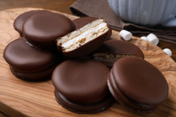 Tasty choco pies on wooden board, closeup view
