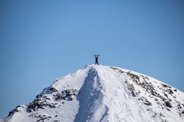 Naklejka na ściany i meble man with snowboard at the top of the snowy mountain