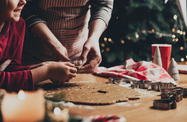 Merry Christmas, Happy New Year. Gingerbread cooking, baking. Mom and daughter make cookies, cut out different shapes of cookies using cutting metal mold on wooden table at kitchen. High quality photo