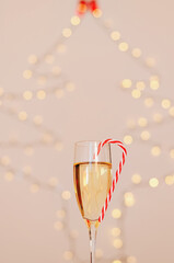 A glass of wine, champagne with red candy against bokeh background close up. Top view. New Year, Christmas mood. Greeting card. Party and holiday celebration concept.