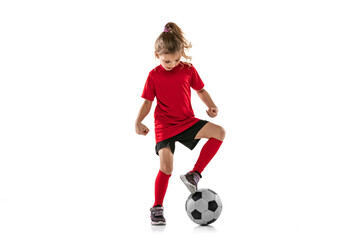 Full-length portrait of child, girl playing football isolated over white background