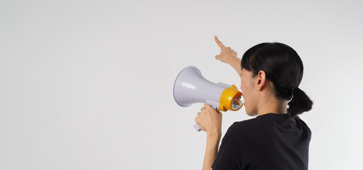 Asian woman is holding megaphone and pointing finger on white background.