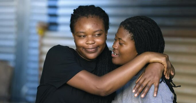Close-up Black African female Lesbian couple showing affection in an informal settlement, South Africa