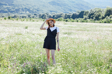 a beautiful woman walks through a field of daisies