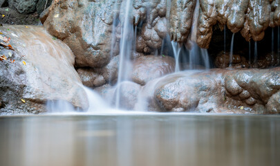 Fototapeta na wymiar Small waterfall with rock formations in the Buda Hills in Hungary, long exposure