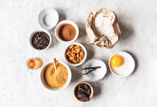 Cooking flat lay of various food ingredients for baking on grey background.