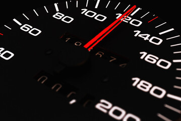 Car speedometer with the needle pointing a high speed at blackground, Speedometer with a red arrow indicating speeding, conceptual image for excessive speeding or careless driving concept.Close-up.