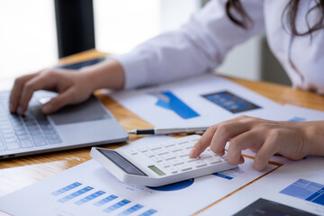 Naklejka premium accounting concept, Businesswoman using a calculator with computer laptop, budget, and loan paper in the office.