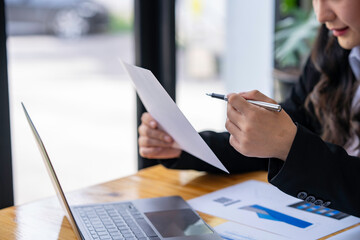 Businesswoman checking company's investment results document in the office