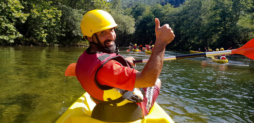 man kayaking in river waving and smiling