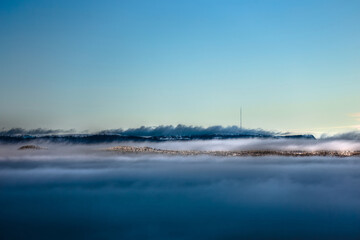 Dense fog and clouds in front of mountains