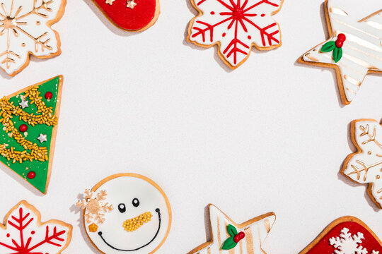 Background with various Christmas cookies flat laid against white background