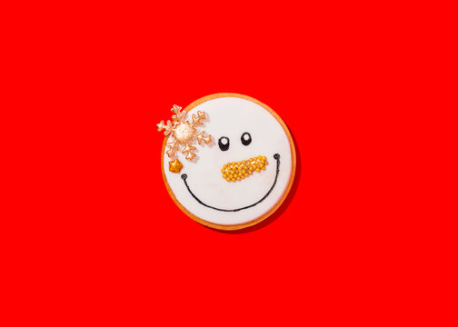 Snowman shaped Christmas cookie against vibrant red background