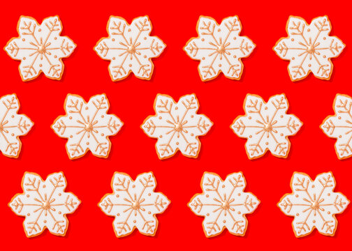 Pattern of snowflake shaped Christmas cookies flat laid against vibrant red background