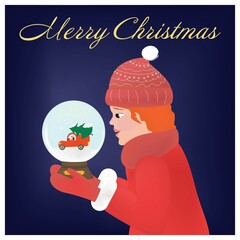 A red-haired girl in red winter clothes is sitting on her knees and holding a snow globe in her hands. Inside the snow globe, a red car is carrying a Christmas tree. Christmas card.
