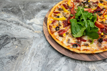 Delicious pizza served on wooden plate.  Top view