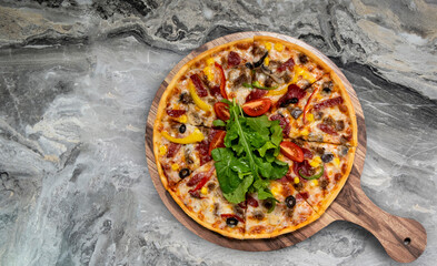 Delicious pizza served on wooden plate.  Top view