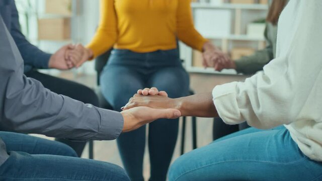 Close-up. A Group Of Mixed-race People Join Hands in a Circle During a Group Therapy Session. Addiction, Violence, Depression. The Concept of Support, Help, Compassion and Empathy.