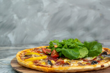 Delicious pizza served on wooden plate.  Top view