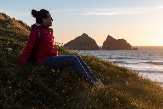 Woman resting while sitting on grass at beach