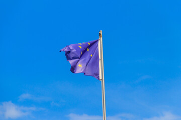 Waving flag of European Union against blue sky