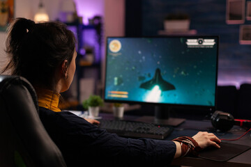 Adult using keyboard and mousepad to play video games on computer. Gamer playing online game in front of monitor with control console and mouse on desk. Modern player with gaming equipment © DC Studio