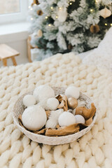 Wicker basket with white Christmas tree toys and balls. Christmas composition.