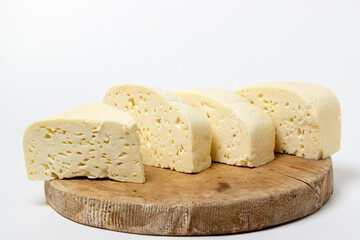 White cheese on a white background. Homemade white cheese on a wooden board. Traditional cuisine
