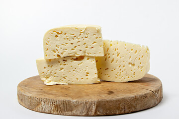 White cheese on a white background. Homemade white cheese on a wooden board. Traditional cuisine