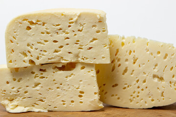 White cheese on a white background. Homemade white cheese on a wooden board. Traditional cuisine