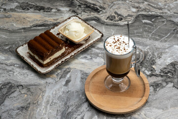 Cup of mocha and slice of tiramisu dessert on marble floor