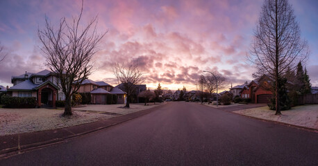 Panoramic View of Residential Suburban Neighborhood Street in a modern city. Frosty Cloudy Winter Morning Sunrise Sky. Fraser Heights, Surrey, Vancouver, British Columbia, Canada.