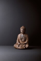 Meditating Buddha Statue on paper background. Copy space. 