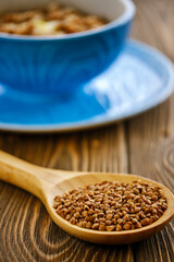 Fresh and tasty buckwheat porridge with butter in a blue cup on a wooden table