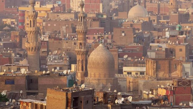 Zoom out shot of islamic quarter of Cairo with houses and mosques. Birds fly against background of mosque and minarets in Cairo, Egypt