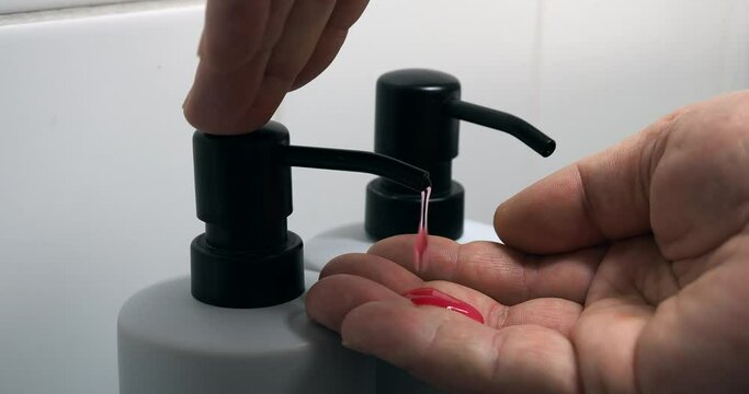 The man takes an antibacterial liquid soap.