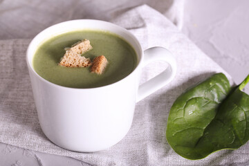 cream spinach soup with crackers is on the table