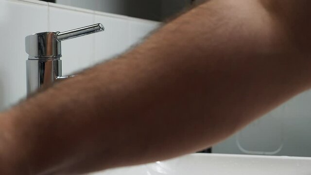 The man washes his hands with soap.