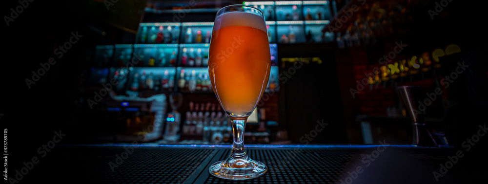 Wall mural glass of light beer stand on bar counter in a bar or pub