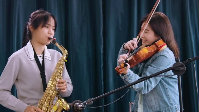 Beautiful Female musician playing instrumental oboe saxophone violin flute guitar use laptop computer singing online streaming broadcast teaching tutorial webcam live show
