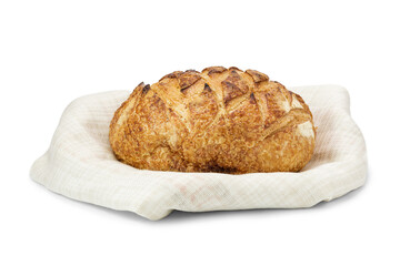 Loaf of freshly baked wheat bread on linen napkin isolated on white background.