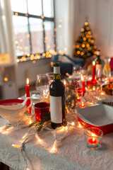 serving, winter holidays and celebration concept - bottle of red wine on table served for christmas dinner party at home