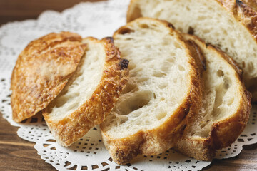 Slices of freshly baked wheat bread on paper napkin on table, selective focus.