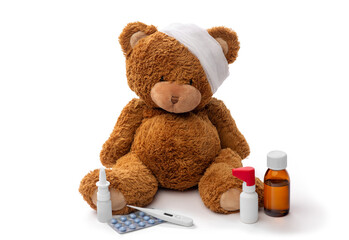 medicine, healthcare and childhood concept - teddy bear toy with bandaged head thermometer and...