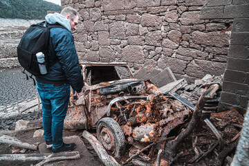 A man explores a car in the Galician Village Aceredo. In 1992 the village was deliberately flooded and submerged underwater. Every few years when the water levels are low, it' reappears.